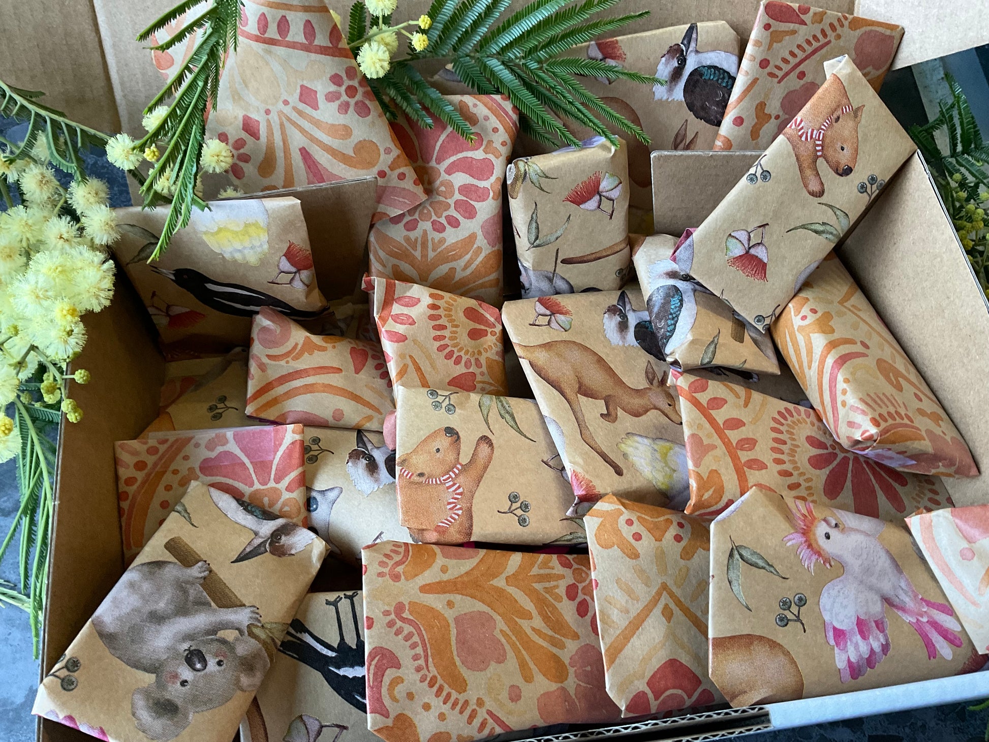 A box of individually wrapped small polymer clay tools as a gift. Each item is wrapped in a lovely kraft and print design including koalas and batik stamped flowers. Gifts include polymer clay cutters, textures, silkscreens and matching cutters and textures.