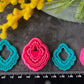 Three hot pink 3d printed polymer clay  cutters arranged on a dark textured surface with decorative flowers around them, set against yellow mimosa and pink/white blossoms. Heirloom Lace Polymer Clay Cutter