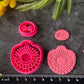 Bright pink 3d printed polymer clay cutters arranged on a dark textured surface, surrounded by decorative flowers and greenery. Morning Ray Polymer Clay Cutter Set