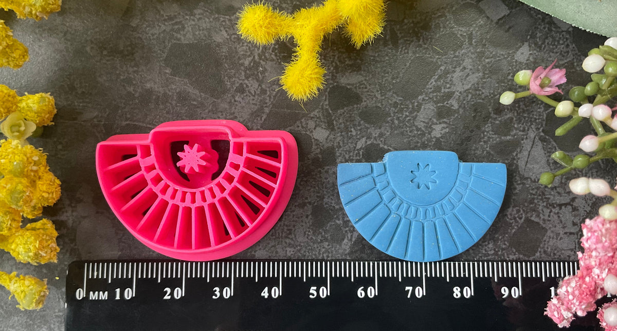 Three pink 3d printed polymer clay cutters arranged on a dark textured surface with decorative yellow and pink flowers around the edges. Palm Fan Polymer Clay Cutter