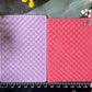 Two rectangular cards with a raised geometric lattice pattern, one lavender and one coral pink, displayed side-by-side on a dark slate background with a black ruler at the bottom and floral decorations in the corners.